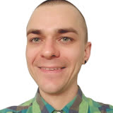 Cheerful man with a small smile, wearing a plaid button-up in various shades of green